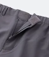 Pantalón gris estilo parachute, corte ancho, con cintura elástica, bolsillos laterales y tobillos ajustables con cordón.