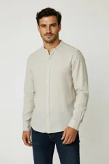 Camisa de algodón a rayas color beige, de corte holgado, con cuello mao y cierre frontal con botones.
