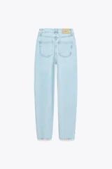 Pantalón de jean celeste claro, de corte mom fit, tiro alto y largo tobillero.