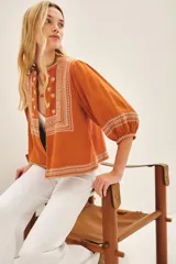 Saco color ladrillo de algodón con fit amplio, largo regular, detalles bordados en el frente y mangas con volumen.