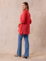 Camisa color beige claro, de corte recto y mangas 3/4 con botón para sujetar.