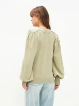 Sweater color gris melange, de tejido de punto, con cuello redondo y mangas abullonadas.