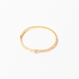 Pulsera rígida dorada con apliques de nácar y strass.