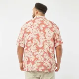 Camisa de manga corta color salmón con estampado de flores blancas, cuello americano y corte recto.