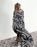 Vestido camisero largo con estampado abstracto en blanco y negro, cierre frontal con botones, mangas 3/4 y cuello camisero.