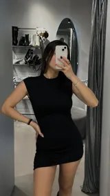 Minivestido negro ajustado al cuerpo, con cuello redondo y sin mangas.