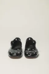 Zapato estilo Mary Jane color marrón, de cuero, con punta redondeada y tira sobre el empeine con hebilla.