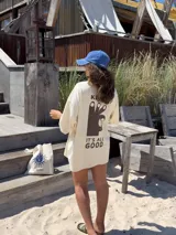 Remerón color ladrillo de algodón, con cuello redondo y mangas cortas. Estampado en la espalda con el texto "KEURO. IT'S ALL GOOD" y un dibujo de una mano haciendo el gesto de "OK".