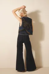 Pantalón jean oxford de tiro medio, color azul oscuro, con recortes laterales y tejido rígido.