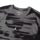 Remera gris con estampado abstracto en negro y logo de Jordan en el pecho.