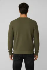 Sweater de algodón color verde militar, con cuello redondo y tejido de fantasía.