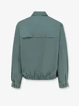 Campera azul con cuello camisero, cierre frontal con cremallera, bolsillos laterales y logo bordado en el pecho.