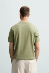 Camiseta verde oliva de punto, corte recto, con cuello redondo y mangas cortas.