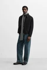 Sobrecamisa de tweed multicolor con cuello solapa, cierre frontal con cremallera, bolsillos laterales y puños abotonados.