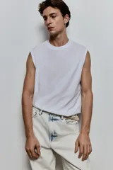 Musculosa blanca de punto liviano con ribete acanalado en cuello y sisas. Confeccionada con tejido funcional COOLMAX®, una fibra de poliéster de secado rápido que elimina la humedad y regula la temperatura corporal.