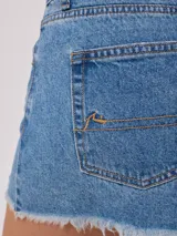 Short de jean negro con roturas y terminaciones desflecadas.