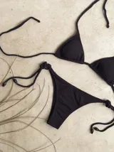 Bikini de triángulo con top ajustable y almohadillas desmontables, y bottom vedetina con tiras laterales.