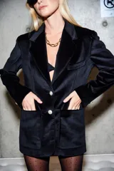 Blazer negro de terciopelo con solapa en V, botones dorados con detalles y bolsillos laterales.