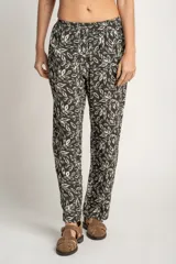 Pantalón recto con estampado de hojas color blanco sobre fondo negro, con cintura elástica y bolsillos laterales.