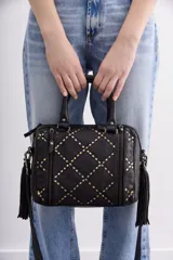 Cartera negra de cuero vacuno con correa desmontable, doble asa corta y cierre superior. Diseño matelassé con tachas metálicas plateadas y doradas en el frente y laterales con cierre.