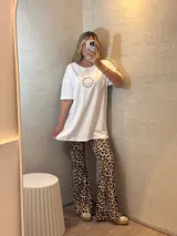 Conjunto de sweater color beige de corte holgado y pantalón acampanado con estampado animal print.