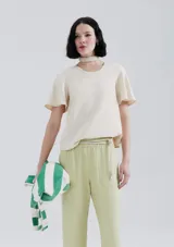Blusa de color beige con mangas cortas tipo evasé y cuello redondo.