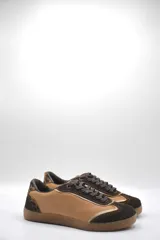 Zapatillas urbanas de cuero color beige con puntera y cordones marrones. Presentan un panel de animal print en el talón y suela de goma color caramelo.