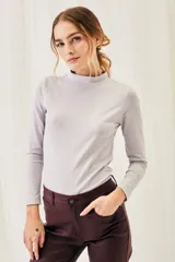 Polera de manga larga color lila, con cuello alto y corte ajustado.