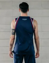 Musculosa de básquet Umbro del Club Nacional de Football, modelo 2025. Diseño azul con detalles en blanco y rojo en cuello y mangas. Incluye logo de Umbro, escudo del club y sponsor Antel en el frente.