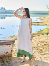 Vestido largo sin mangas color beige con ruedo verde, de corte amplio y estilo casual.
