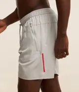 Bermuda deportiva negra sin estampado, con cintura elástica ajustable con cordón, y bolsillo lateral con cierre de cremallera contrastante.