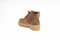 Bota acordonada de cuero color arena, con interior forrado en tela escocesa roja y negra, y suela de goma color caramelo.