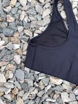 Top deportivo color burdeos con espalda tipo nadadora, diseñado para mayor contención y comodidad durante entrenamientos.