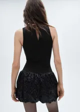 Minivestido negro con cuerpo ajustado sin mangas y falda globo cubierta de lentejuelas.