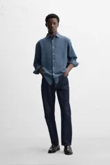 Camisa de vestir azul petróleo, corte regular, confeccionada en mezcla de algodón. Cuenta con cuello solapa, mangas largas con puños abotonados y cierre frontal con botones.
