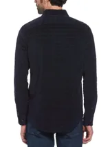 Camisa de corderoy azul marino con rayas horizontales en relieve, corte slim fit, cuello abotonado, manga larga y bolsillo plaqué en el pecho.