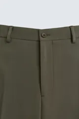 Pantalón de vestir color verde oliva, corte slim fit, con bolsillos laterales y traseros de ojal con botón. Cierre frontal con cremallera y botón.
