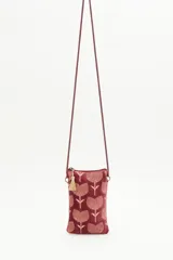 Bolso pequeño tipo cartera porta celular confeccionado en terciopelo color borgoña, con diseño bordado de tulipanes dorados. Tiene acceso superior con cierre y tirante en hilo metalizado, más cordón largo que permite colgarlo al cuerpo.