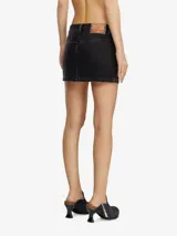 Falda corta de denim negro, tiro bajo, con diseño clásico de cinco bolsillos y costuras visibles. Presenta una pequeña etiqueta roja y blanca en el bolsillo delantero.