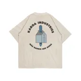 Remera manga corta color crudo, corte oversize, con estampa en la espalda que incluye el logo de la marca Kaboa Industries y la frase "Más barrio que moda".
