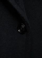 Abrigo largo negro con cuello solapa y cierre frontal con botones.