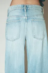 Pantalón de jean azul oscuro, de corte wide leg y tiro medio, con cinco bolsillos y cierre frontal con cremallera y botón metálico.