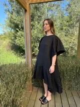 Vestido largo color beige, de corte amplio, con mangas cortas abullonadas y volado en el ruedo.