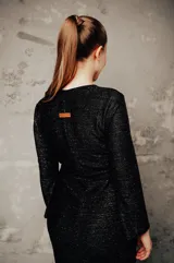 Vestido negro de punto con brillo, corte ajustado y mangas largas acampanadas.