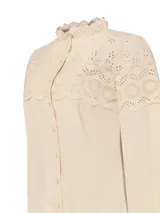 Blusa beige de algodón orgánico con cuello alto y detalles de broderie en la parte superior.