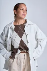 Sobrecamisa color beige de gabardina con cuello camisero, cierre frontal con botones a presión, dos bolsillos de parche en el pecho y corte holgado.