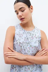 Blusa celeste con estampa floral, sin mangas.