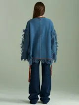 Sweater negro oversize de lana con cuello redondo, bordado central en forma de trenza, laterales con cuadrillé y mangas acampanadas desflecadas.