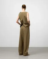 Pantalón de vestir ancho color caqui, con pinzas delanteras, trabillas en la cintura y bolsillos laterales y de vivo traseros.