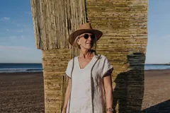 Túnica negra con escote en V y mangas cortas con detalle de lentejuelas en los bordes.